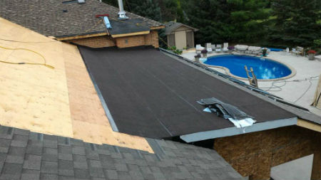 Looking at a home in Kitchener with a combination flat roof and shingle roof.